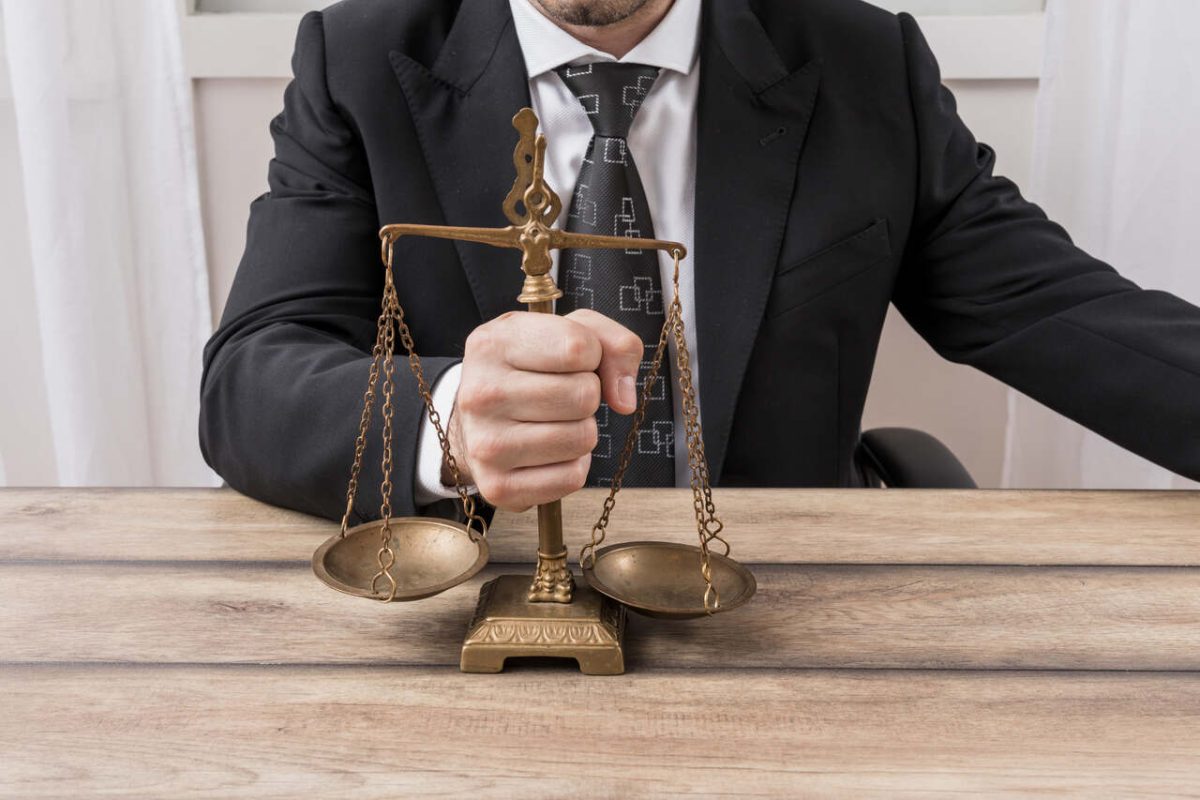 Advogado mostra balança da justiça em escritório